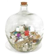 Large glass carboy containing numerous assorted matchboxes