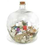 Large glass carboy containing numerous assorted matchboxes