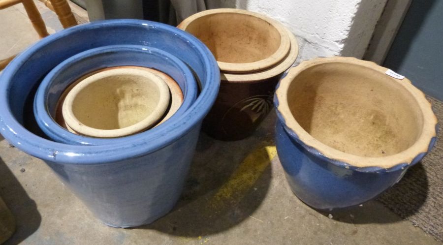 Seven modern glazed plant pots of varying sizes