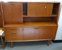 Teak mid-century modern lounge unit with cocktail cabinet to the left, sliding cupboard doors open