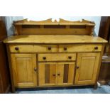 Vintage pine sideboard with a low shelf rack above the serpentine front, three drawers and four
