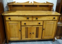Vintage pine sideboard with a low shelf rack above the serpentine front, three drawers and four