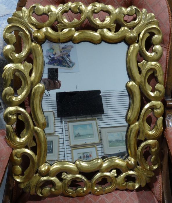 Shaped mirror in carved and pierced wood and gilt-finish frame, 59cm x 49cm