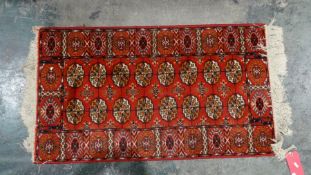 Modern red ground rug with elephant foot guls to central field, in reds, oranges and creams, 116cm x