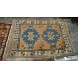 Pink ground rug with two central blue ground motifs, on a foliate border, 193cm x 134cm