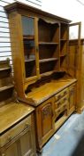 Arts & Crafts-style oak dresser, the ogee moulded cornice above assorted shelves and two glazed