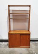 Two mid-century modern teak lounge units with assorted open shelves, one with cocktail cabinet above