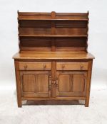 Mid-coloured Ercol dresser, the waterfall top with two plateracks, on a base of two drawers and