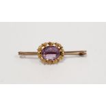 Gold coloured metal and amethyst bar brooch set single oval faceted stone