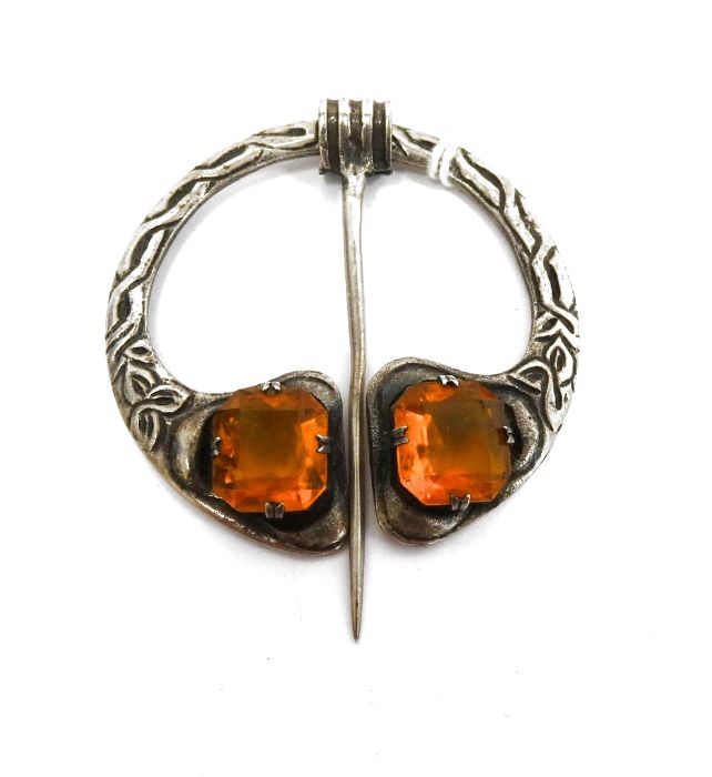 Silver and citrine plaid brooch of Celtic form and set with two cut citrines, with movable pin,