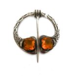 Silver and citrine plaid brooch of Celtic form and set with two cut citrines, with movable pin,
