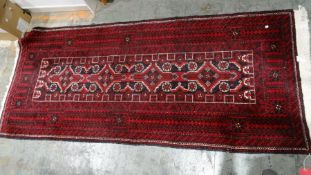 Iranian-style red ground rug with four repeating motifs to the central field, on a stepped border