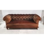 Victorian Chesterfield sofa in brown upholstery, on turned front legs to castors Condition