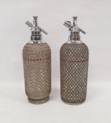 Pair of soda syphons with silver coloured metal grille marked Sparklets Ltd. London