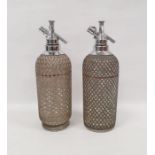Pair of soda syphons with silver coloured metal grille marked Sparklets Ltd. London