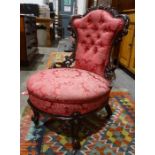 Low Victorian chair with carved and pierced mahogany frame, pink upholstered seat and back, on