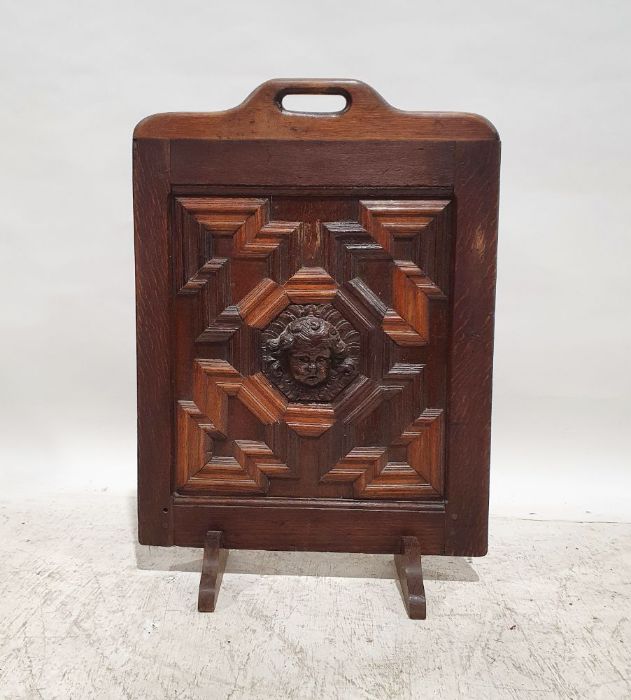 20th century oak fire screen with applied moulded mask decoration