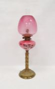 Brass oil lamp with pink glass bowl decorated with daisies, twisted column with chimney and