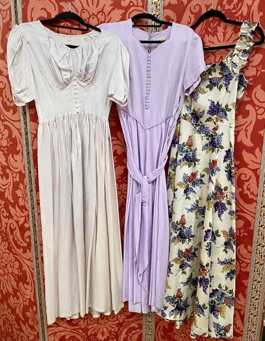 Seven various 1950's satin evening dresses to include a cream ground printed with lilacs,