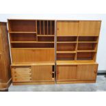 Two mid-century teak lounge units with sliding doors, open shelf recesses and drinks cabinet, on