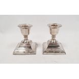 Pair of George V silver weighted squat candlesticks with square stepped base, Chester 1910, maker'