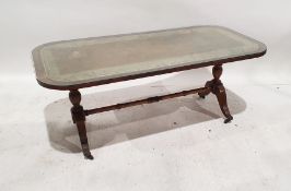 20th century mahogany and leather-topped coffee table on turned end supports to ogee legs,