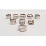 Three silver-rimmed cut glass personal salts and six various silver napkin rings