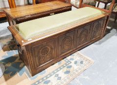 20th century oak coffer with padded leather top with carved floral and knight's helmet panel by
