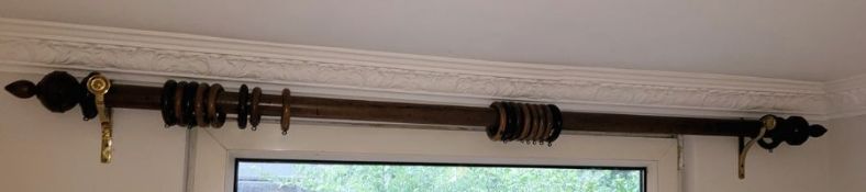 Wooden curtain rail with wooden rings and turned ends and a pair of brass rail holders Condition