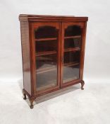 Early 20th century mahogany cabinet, the two glazed doors enclosing shelves, on squat cabriole legs,