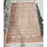 Eastern style red ground rug with central stylised repeating geometric design with multiple