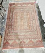 Eastern style red ground rug with central stylised repeating geometric design with multiple