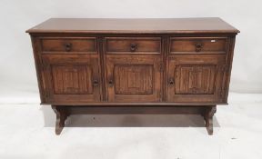 20th century oak sideboard with three drawers above three linenfold cupboard doors, on trestle-style