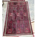 Large Turkish style red ground rug with repeating stylized animal and geometric design with