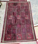 Large Turkish style red ground rug with repeating stylized animal and geometric design with