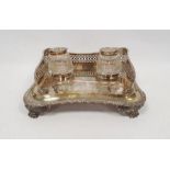 George III silver inkstand with two glass and lidded silver inkwells, the shaped rectangular stand