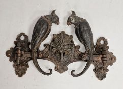 Paul Koch bronze metal coat rack with central mask hook, flanked by hinged parrots, their tails