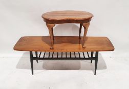Mid-century modern teak top coffee table with black stained magazine rack under, on tapering
