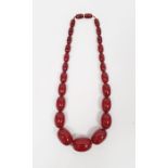 A graduated red amber beaded necklace, 60g approx.