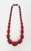 A graduated red amber beaded necklace, 60g approx.
