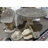 Composite stone circular garden table with incised floral decoration to the centre, on plinth