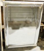 Modern bevelled edged mirror within a silver-coloured metal frame