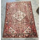 Large Eastern style pink ground rug with central lozenge medallion on a herati-filled field with