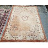 Large peach ground Chinese superwash carpet with central medallion enclosed by floral pattern to a
