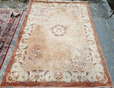 Large peach ground Chinese superwash carpet with central medallion enclosed by floral pattern to a
