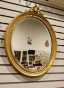 Modern oval gilt painted framed mirror with floral engraved detail