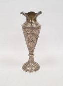 Foreign silver-coloured metal tapering vase on a circular base, repousse floral decorated,