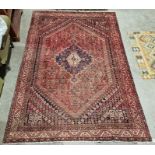South West Persian Shiraz red ground carpet with centralised geometric medallion enclosed by