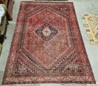 South West Persian Shiraz red ground carpet with centralised geometric medallion enclosed by