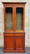 Edwardian mahogany bookcase with glazed double doors above two frieze drawers and double panelled